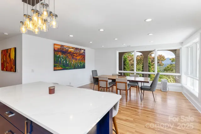 a view of a dining room with furniture a chandelier and wooden floor
