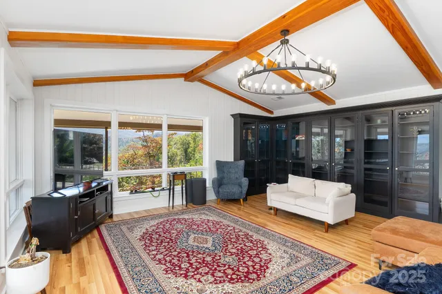 a living room with furniture a rug and a large window