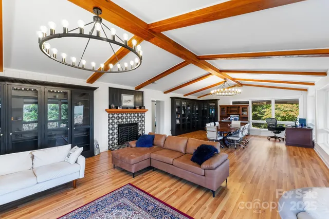 a living room with fireplace furniture and a large window