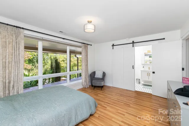 a bedroom with a bed and a large window