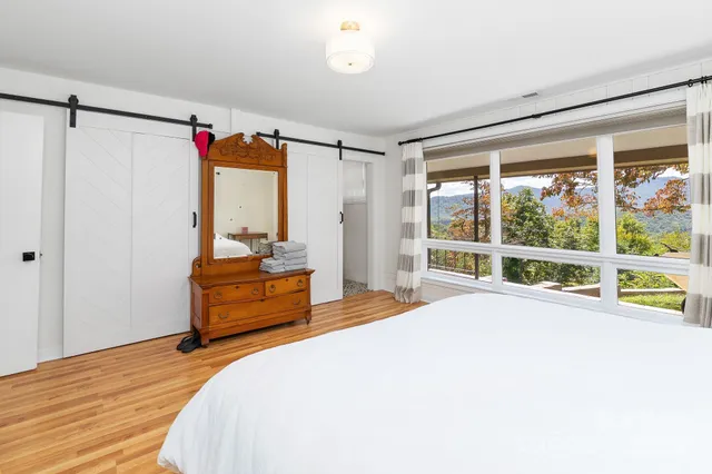 a bedroom with a bed and a large window