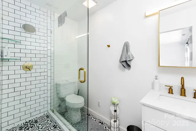 a bathroom with a sink a toilet and shower