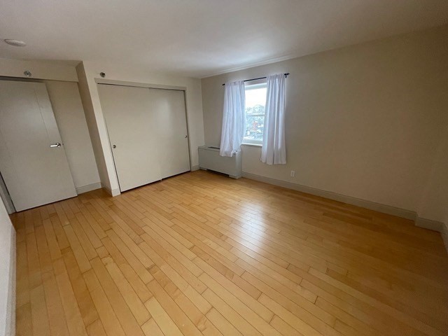 1600 Beacon Street, Unit 1012 Brookline, MA 02446 - Photo 19 of 27 an empty room with wooden floor and windows