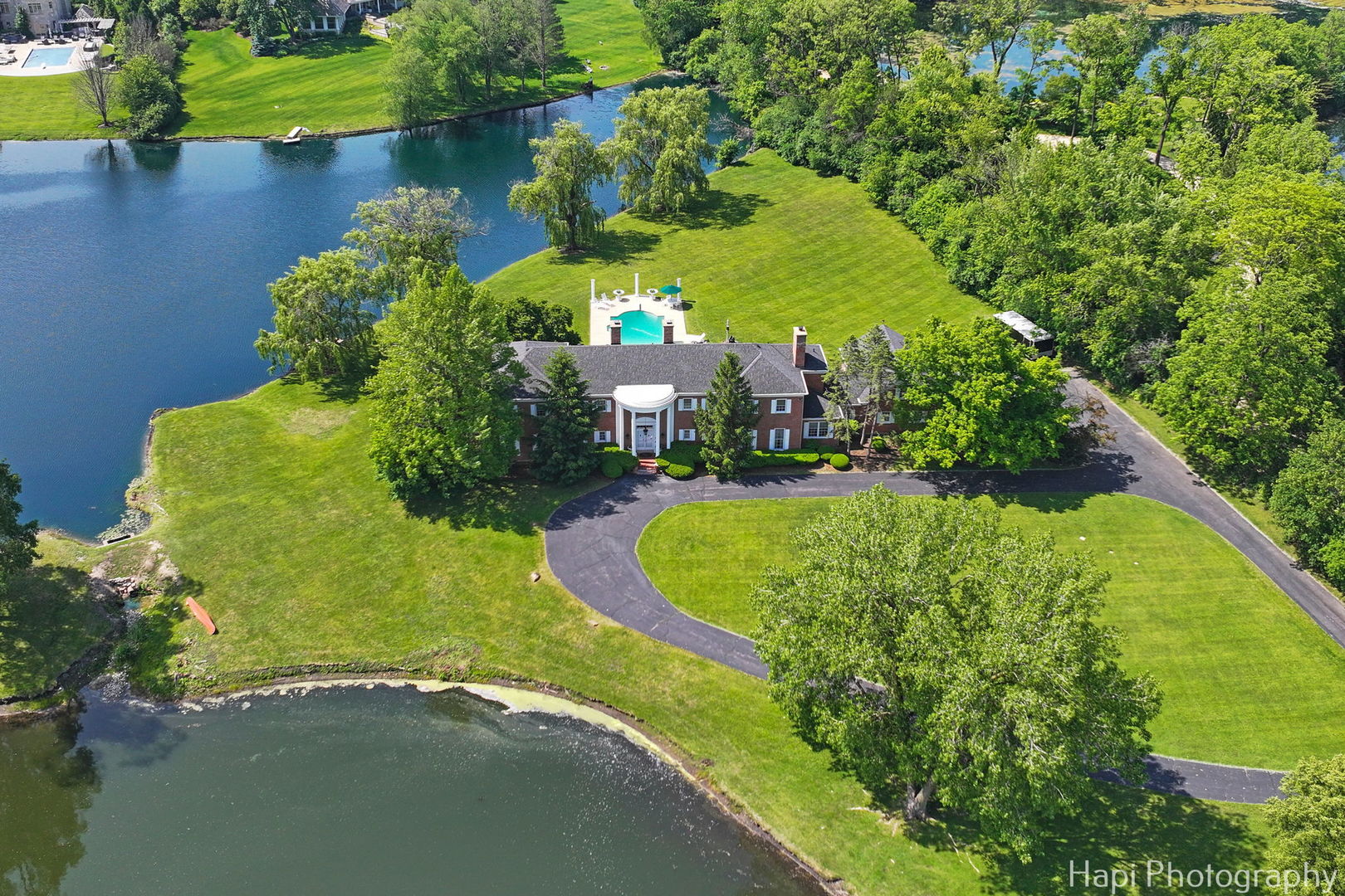 an aerial view of a house with a yard and lake view