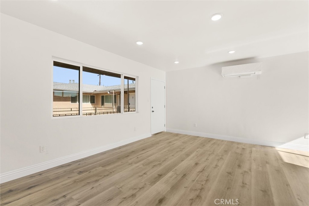 19237 Bryant Street, Unit 16 Northridge, CA 91324 - Photo 12 of 15 an empty room with wooden floor and windows