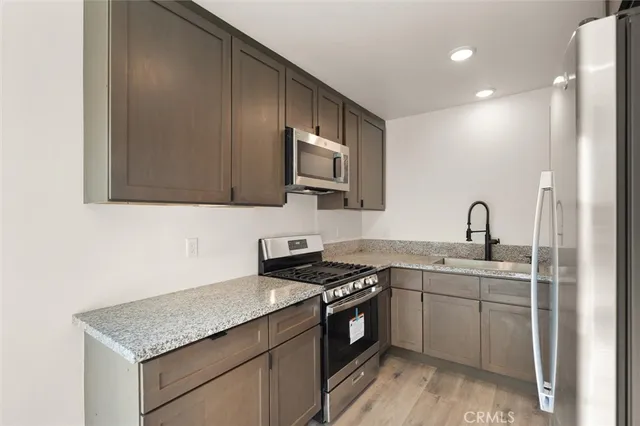 a kitchen with stainless steel appliances granite countertop a sink stove and cabinets