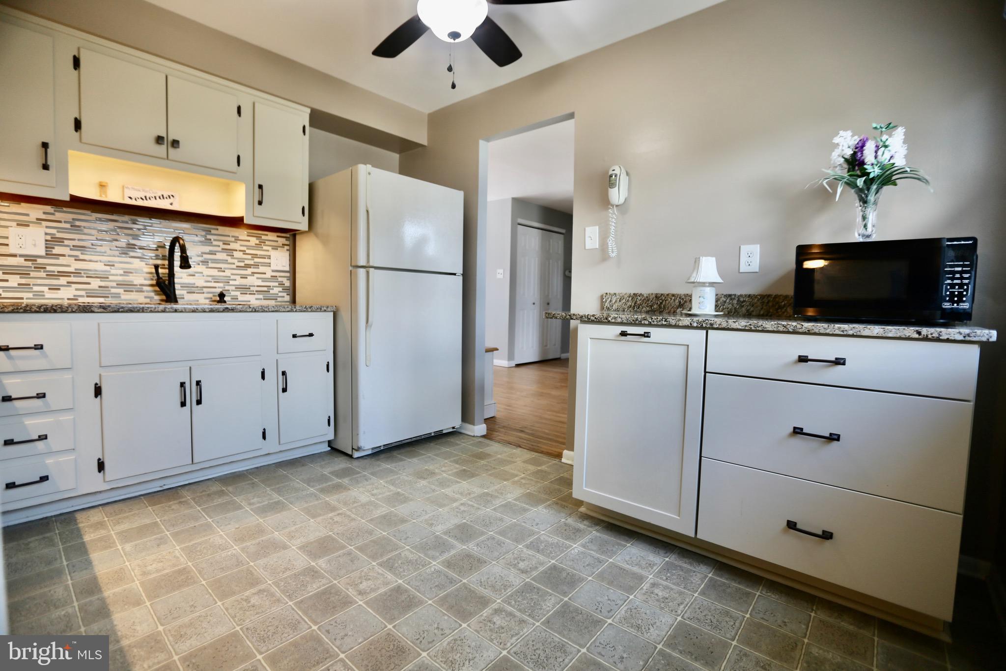 242 Tilford Road Somerdale, NJ 08083 - Photo 11 of 29 a kitchen with granite countertop a stove a sink and a refrigerator