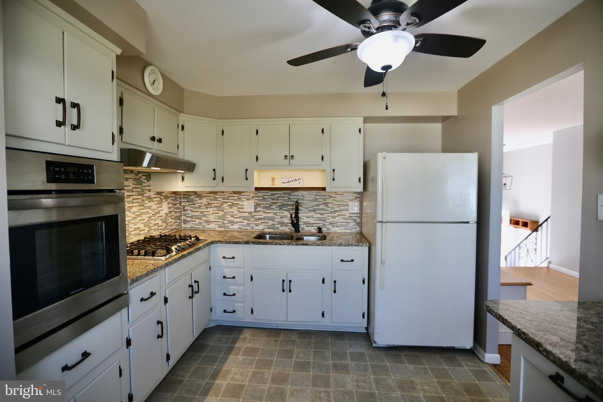 242 Tilford Road Somerdale, NJ 08083 - Photo 9 of 29 a kitchen with granite countertop white cabinets white stainless steel appliances and a refrigerator