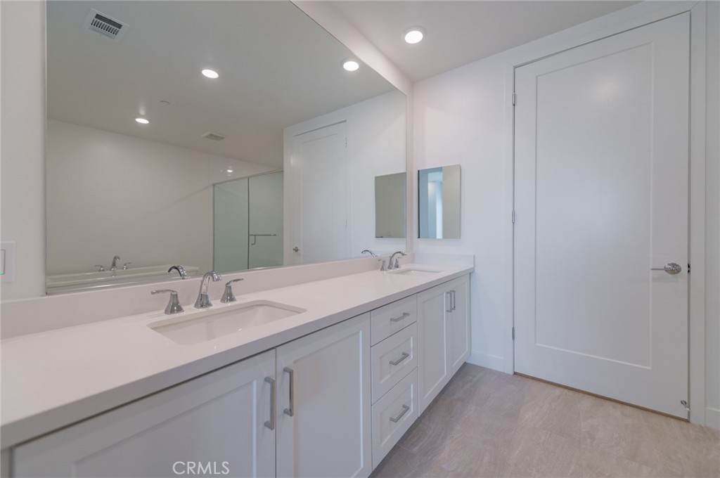 1703 Rivington Irvine, CA 92612 - Photo 12 of 42 a bathroom with double sink and a mirror