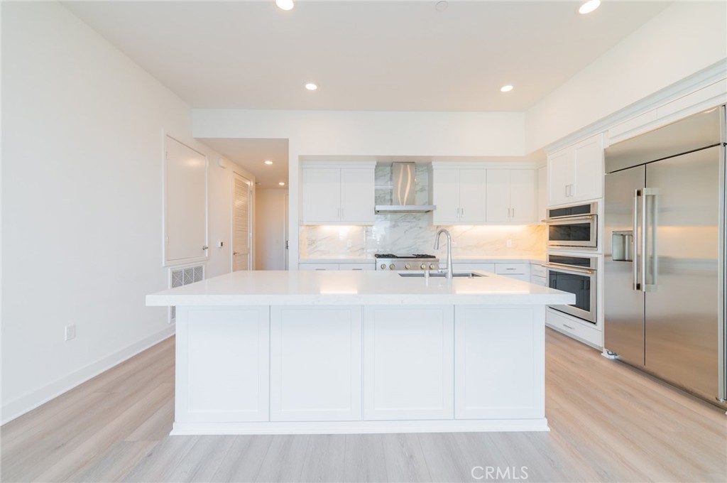 1703 Rivington Irvine, CA 92612 - Photo 3 of 42 a kitchen with kitchen island a sink stainless steel appliances and white cabinets