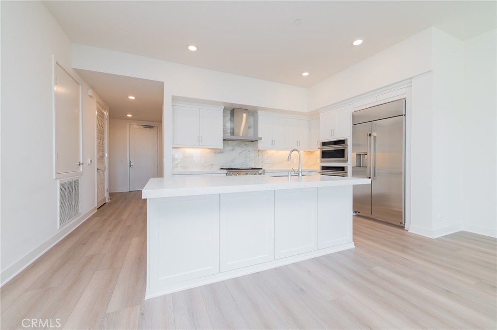 1703 Rivington Irvine, CA 92612 - Photo 7 of 42 a kitchen with stainless steel appliances granite countertop a refrigerator sink and white cabinets