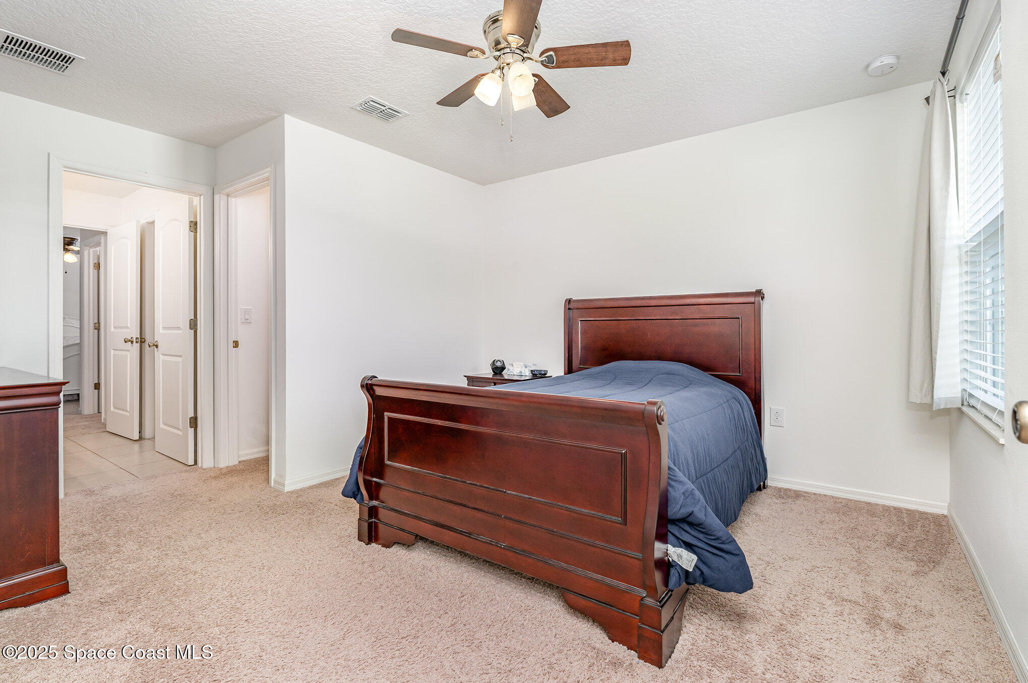 352 Gordon Road Northwest Palm Bay, FL 32907 - Photo 41 of 71 a bedroom with a bed and a ceiling fan