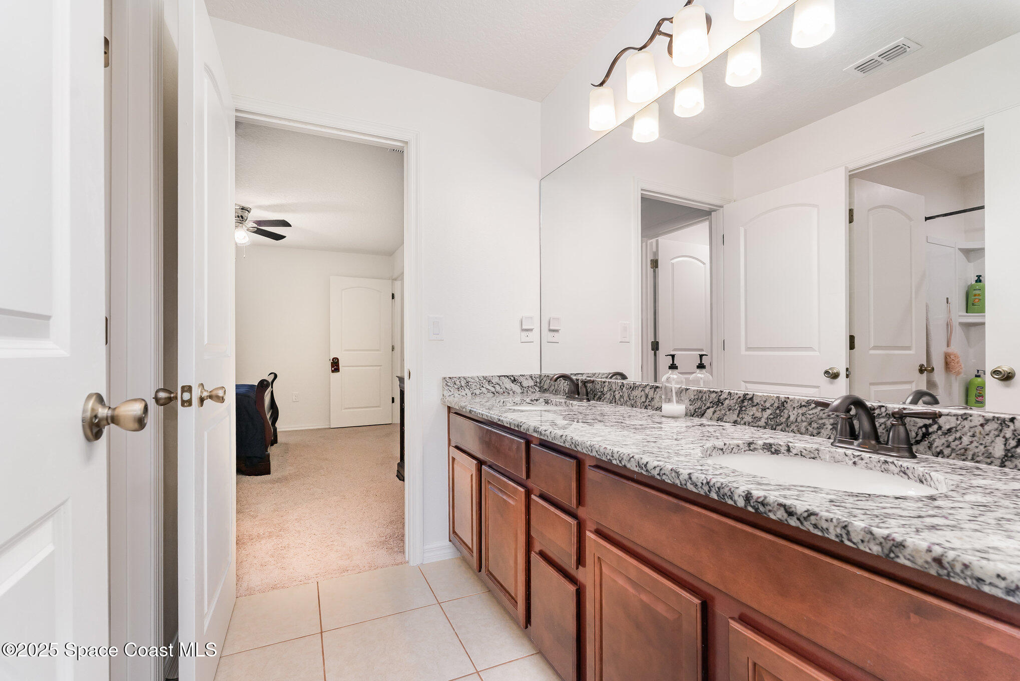 352 Gordon Road Northwest Palm Bay, FL 32907 - Photo 44 of 71 a bathroom with a granite countertop sink a large mirror and shower