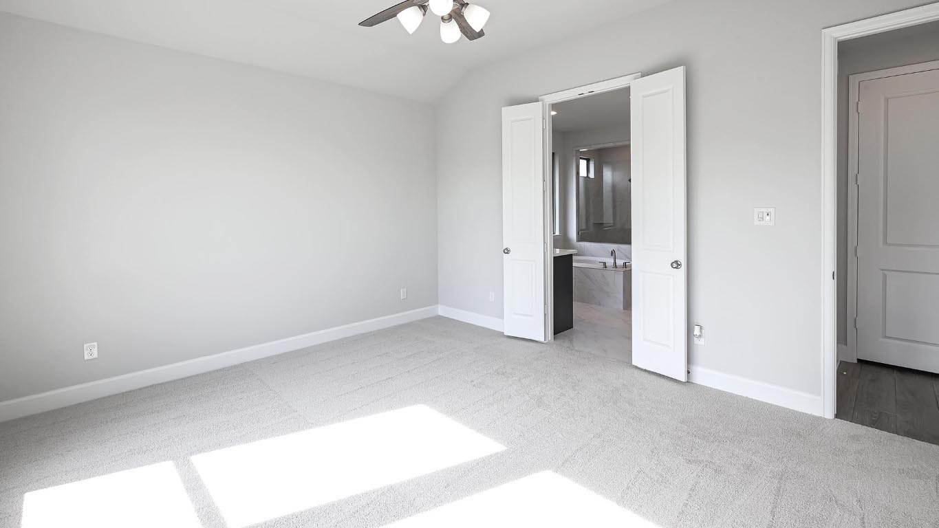 285 Prickly Poppy Loop Kyle, TX 78640 - Photo 19 of 40 Unfurnished bedroom with light colored carpet, ceiling fan, lofted ceiling, and connected bathroom