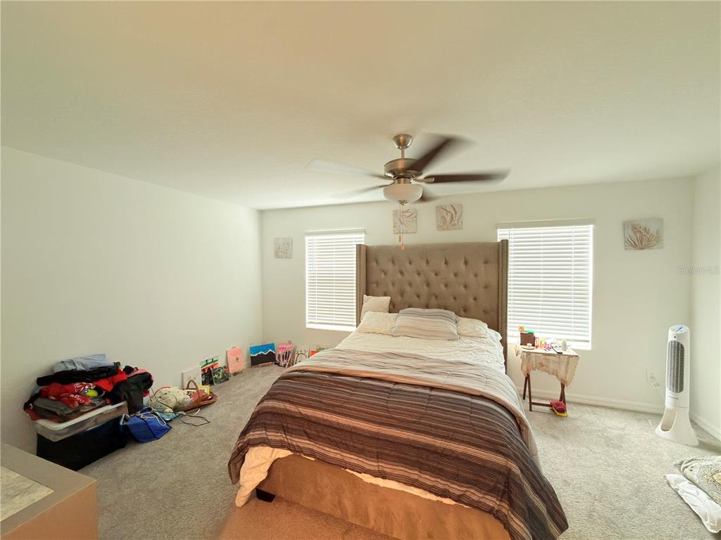 253 Tulip Banded Way Ruskin, FL 33570 - Photo 18 of 20 a bedroom with a bed and a chandelier