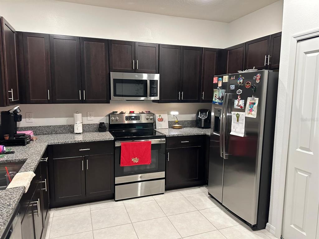 253 Tulip Banded Way Ruskin, FL 33570 - Photo 4 of 20 a kitchen with stainless steel appliances granite countertop a refrigerator and a stove top oven
