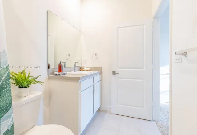 a bathroom with a sink and mirror with toilet
