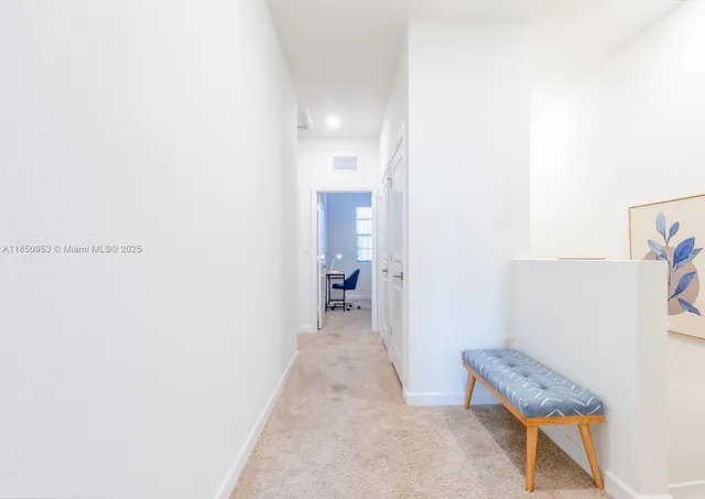 a view of a hallway with closet and a bathroom
