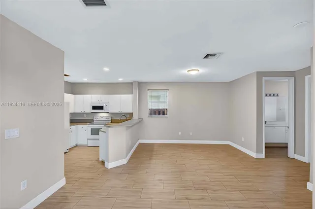 a view of a room with wooden floor and a window