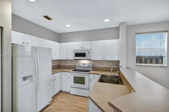 an aerial view of residential houses with outdoor space and lake view