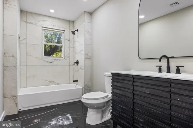 a bathroom with a toilet a sink and bathtub