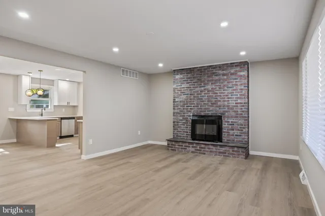 an empty room with wooden floor and fireplace