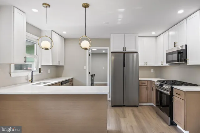 a kitchen with stainless steel appliances granite countertop a sink a stove and a refrigerator