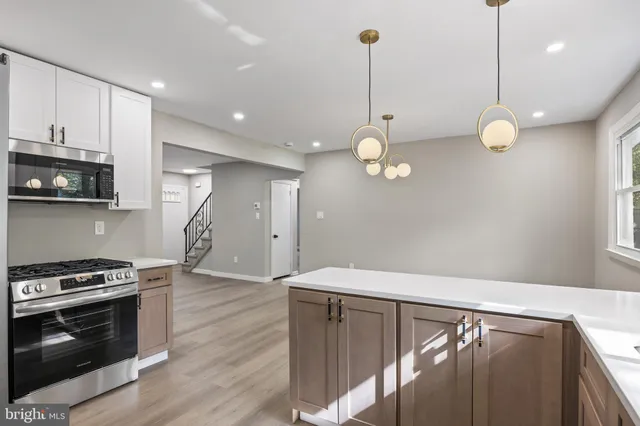 a view of kitchen with stainless steel appliances cabinets and wooden floor