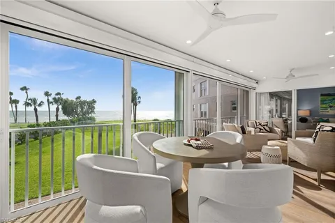 a dining room with furniture and a floor to ceiling window