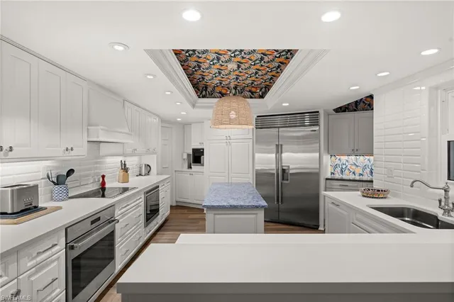 a kitchen with stainless steel appliances granite countertop a sink a stove and a refrigerator