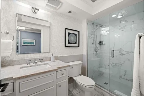 a bathroom with a granite countertop sink toilet and shower