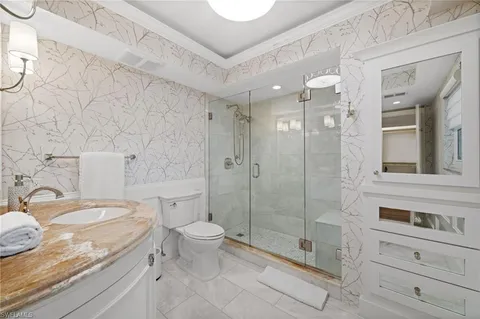 a bathroom with a granite countertop sink a toilet and shower