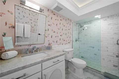 a bathroom with a granite countertop sink a toilet and shower