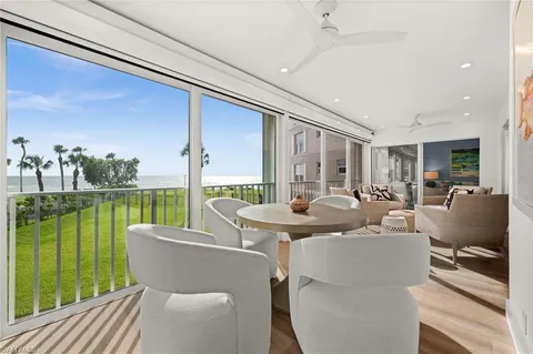 a dining room with furniture and a floor to ceiling window
