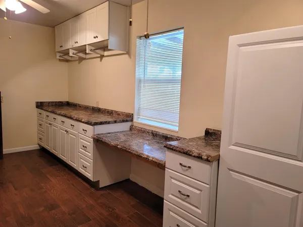 a kitchen with granite countertop cabinets stainless steel appliances and a wooden floor