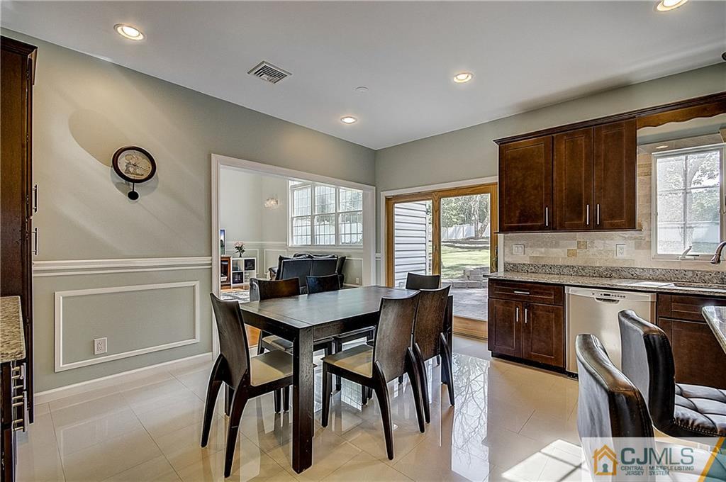 35 Williams Road Edison, NJ 08820 - Photo 13 of 47 a kitchen with stainless steel appliances granite countertop a stove a sink dishwasher a dining table and chairs with wooden floor