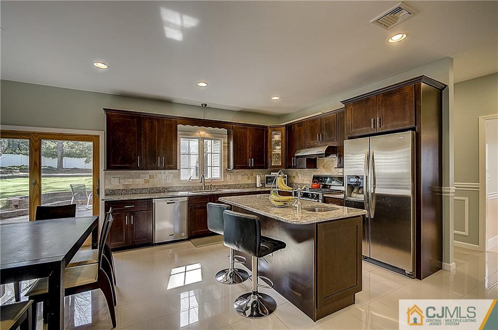 35 Williams Road Edison, NJ 08820 - Photo 17 of 47 a kitchen with refrigerator cabinets dining table and chairs