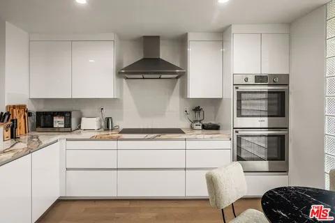 a kitchen with a sink stainless steel appliances and white cabinets