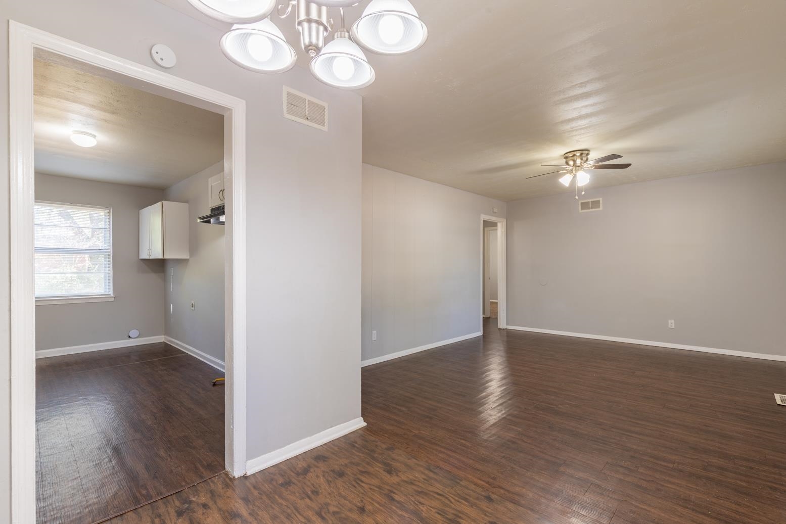 5581 Lochinvar Road Memphis, TN 38116 - Photo 8 of 19 an empty room with wooden floor and windows