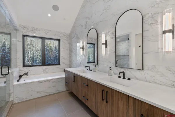 a spacious bathroom with a double vanity sink a mirror and a bathtub