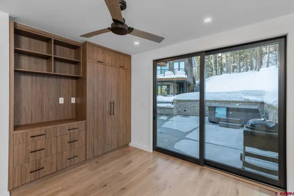 a view of a hallway with wooden floor and windows