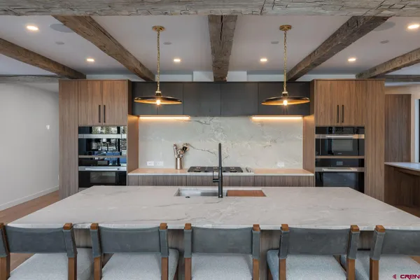a kitchen with kitchen island a sink stove and refrigerator