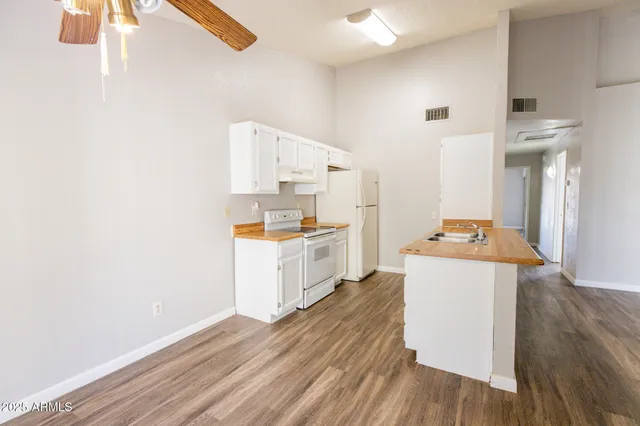 a kitchen with a refrigerator and white cabinets