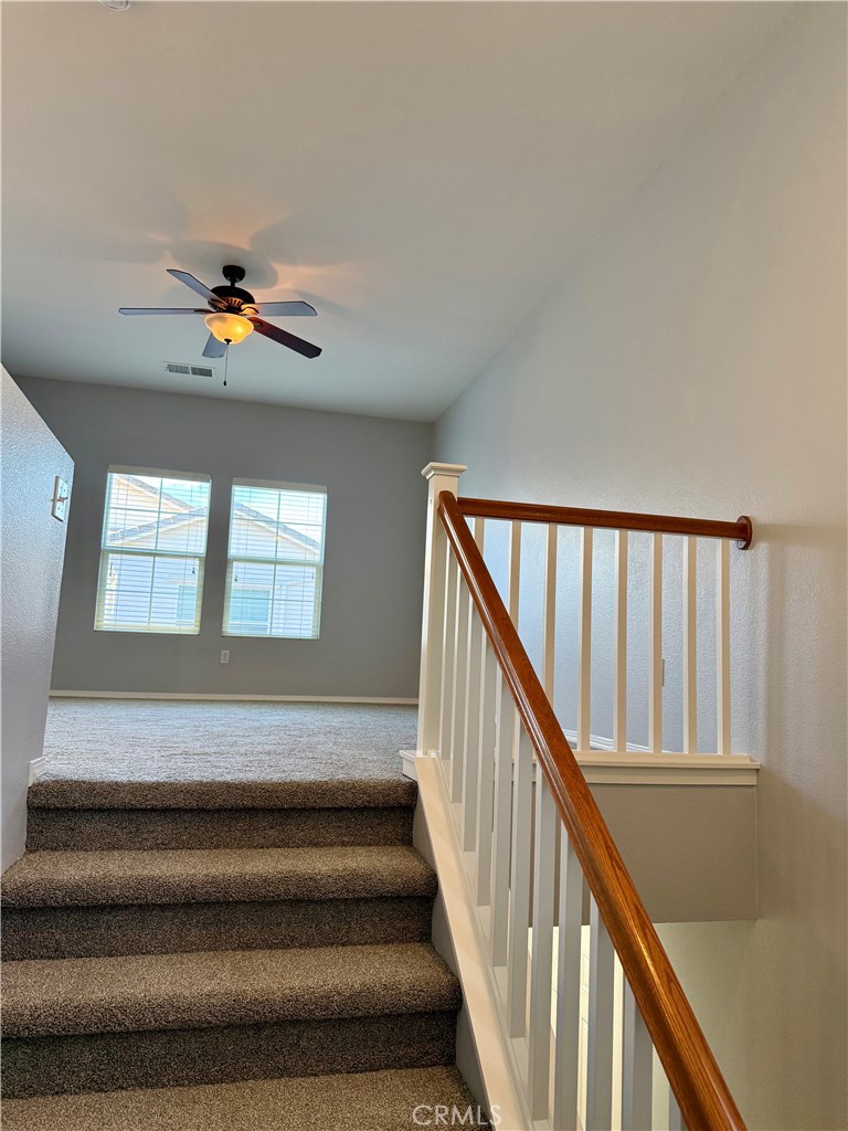 36368 Grazia Way Winchester, CA 92596 - Photo 9 of 27 a view of staircase with white walls and a rug