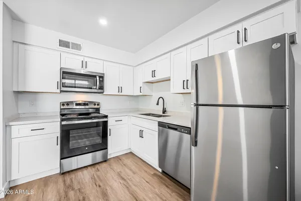 a kitchen with stainless steel appliances a refrigerator sink and microwave