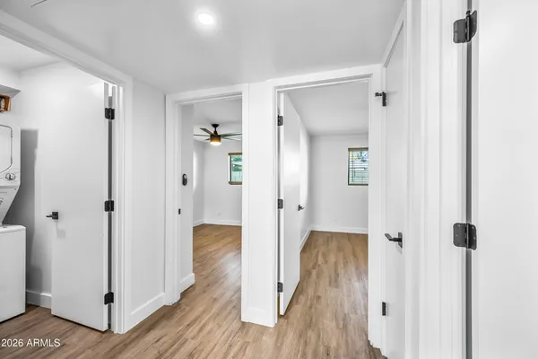 a view of a hallway with wooden floor and closet area