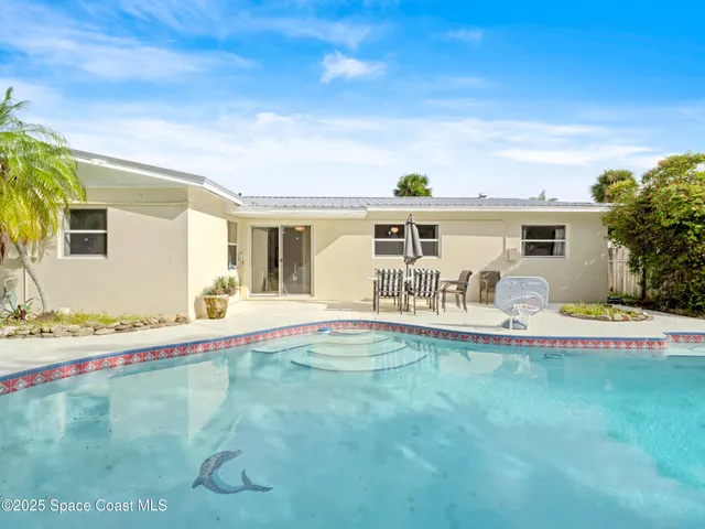 a view of a house with backyard and sitting area