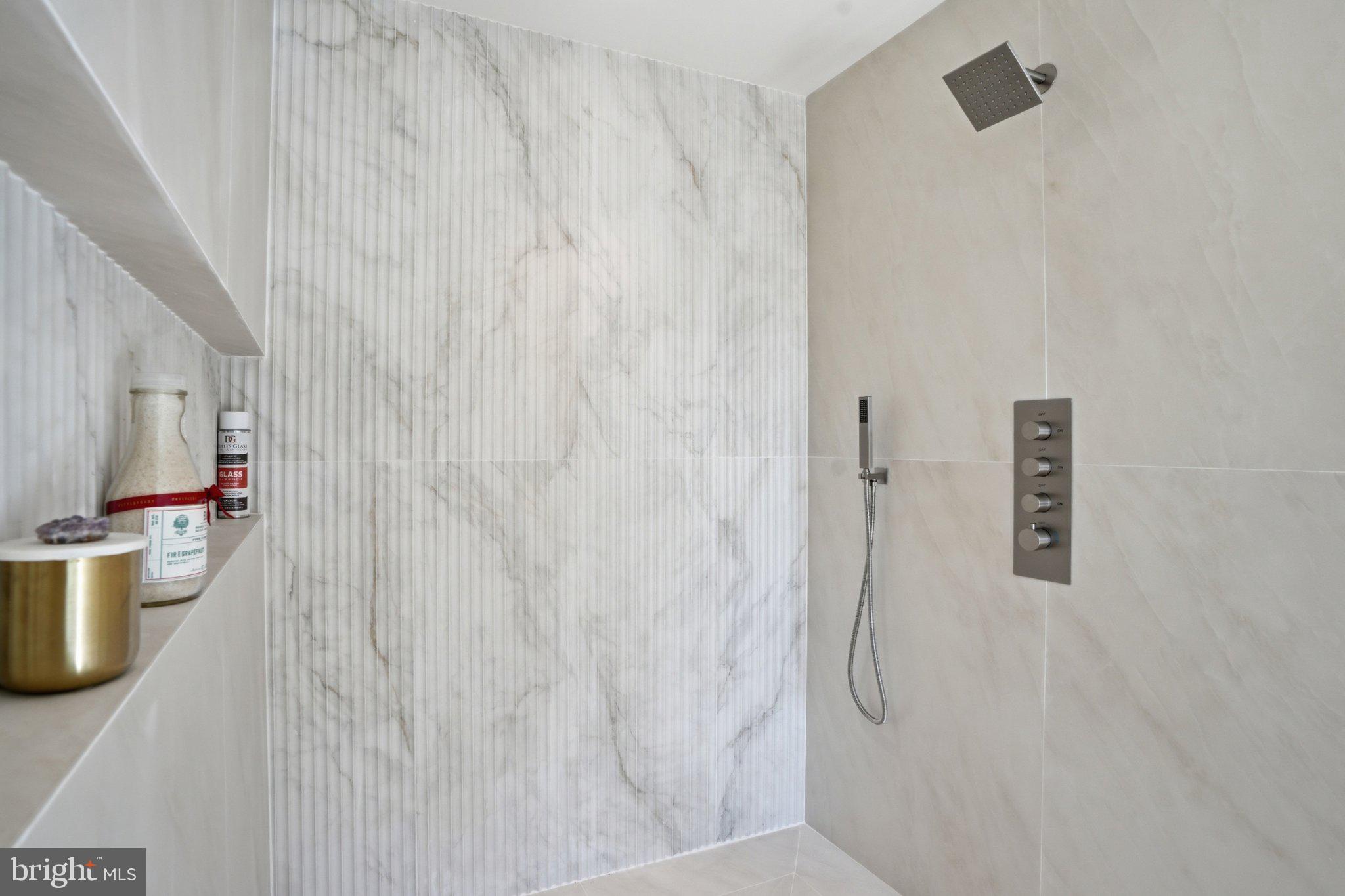 7421 Magarity Road Falls Church, VA 22043 - Photo 54 of 66 Sleek marble shower with modern fixtures.