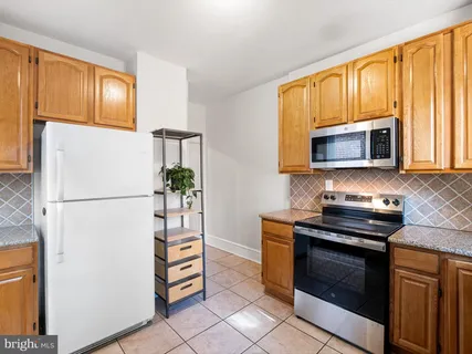 a kitchen with stainless steel appliances granite countertop a refrigerator stove a sink dishwasher and microwave