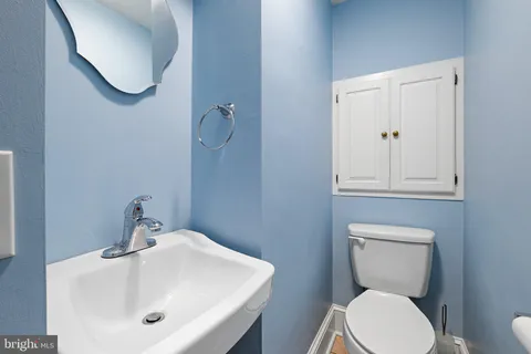 a bathroom with a toilet a sink and mirror